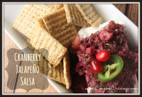Cranberry jalapeno salsa spooned over cream cheese on a white plate with crackers