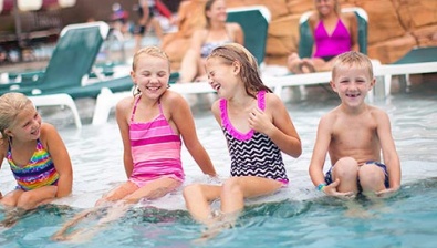 Kids sitting on the side of the pool at the Great Wolf Lodge Traverse City Michigan Location