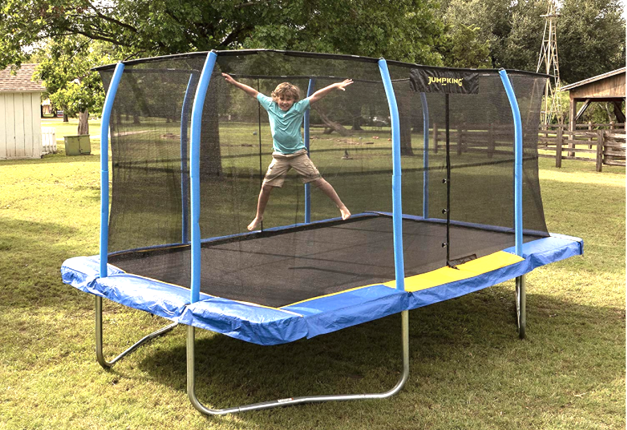 Boy in green shirt jumping on a rectangle trampoline